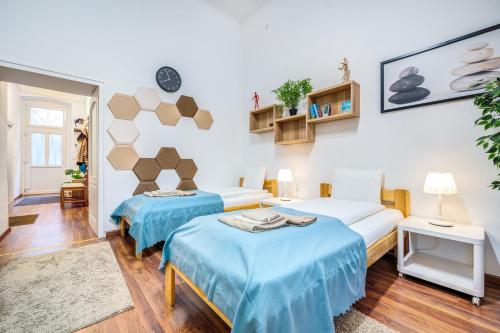 ブダペストにあるDiamond Residence - BimBam Bajzaの青いシーツが備わるベッド2台付きの部屋