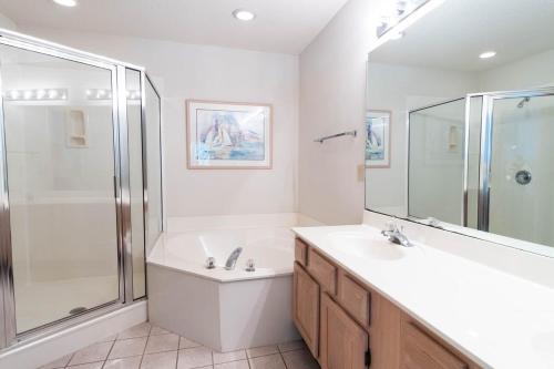een badkamer met een bad, een wastafel en een douche bij Tidewater- Teal lake #2521 in North Myrtle Beach