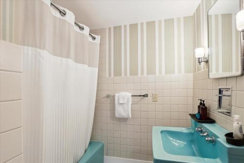 La salle de bains est pourvue d'un lavabo bleu et d'un rideau de douche. dans l'établissement Mansfield Gateway House, à Stowe
