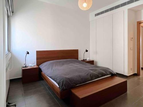 una camera con un letto con due comodini e due lampade di Gorgeous 3Br Achrafieh Apt a Beirut