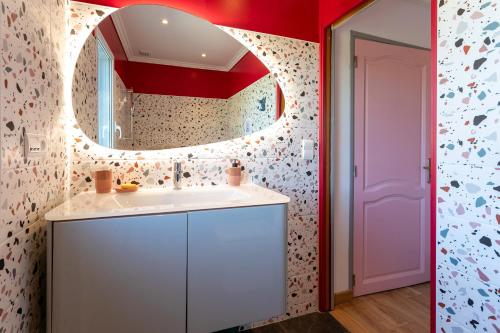 een badkamer met een witte wastafel en een spiegel bij Villa avec jacuzzi, hammam et sauna in Plestin-les-Grèves