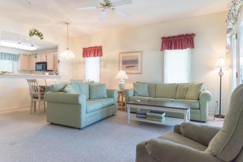 a living room with two couches and a table at Tidewater Teal Lake 1323 in North Myrtle Beach