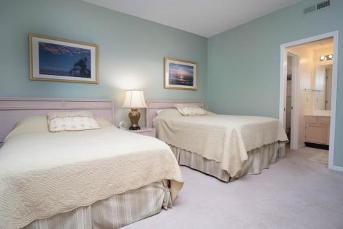 een slaapkamer met 2 bedden en een badkamer bij Teal Lake 2323 in North Myrtle Beach