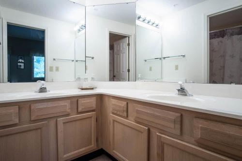 een badkamer met 2 wastafels en een grote spiegel bij Teal Lake 2323 in North Myrtle Beach