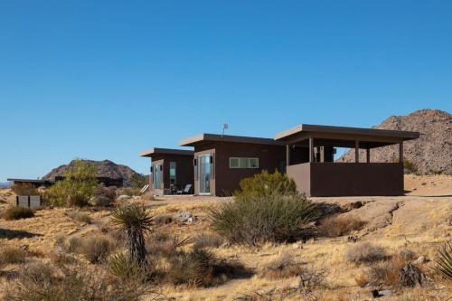 a house in the desert with mountains in the background at Shelter 2 l A Classic At Joshua Tree Park Entrance in Joshua Tree