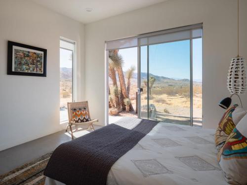 a bedroom with a bed and a view of the desert at Shelter 1- A Classic- At Joshua Tree Park Entrance in Joshua Tree