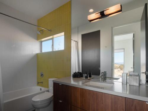 a bathroom with a sink and a toilet and a mirror at Shelter 1- A Classic- At Joshua Tree Park Entrance in Joshua Tree