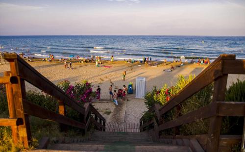 a group of people on a beach with the ocean at Apartments Kione Playa Romana Park in Alcossebre