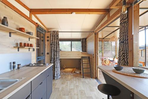- une cuisine dans une petite maison avec une grande fenêtre dans l'établissement Camping Le Marais Sauvage, à Le Mazeau