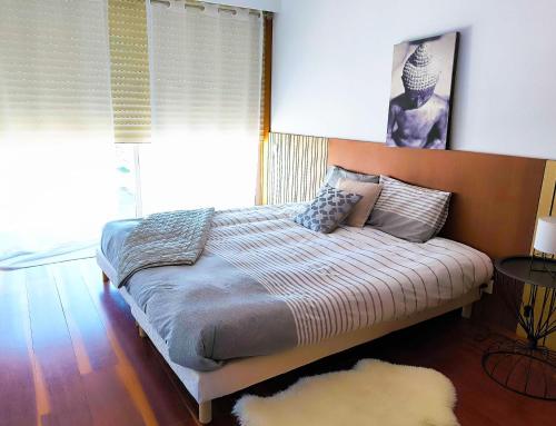 a bedroom with a bed with a large window at Apartamento Esposende Quinta da Barca in Barca do Lago