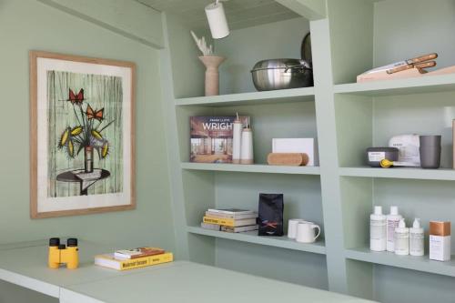 a kitchen with shelves with books and a picture at The Bungalows by Homestead Modern in Joshua Tree
