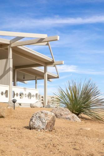a pavilion with rocks in front of a building at The Bungalows by Homestead Modern in Joshua Tree