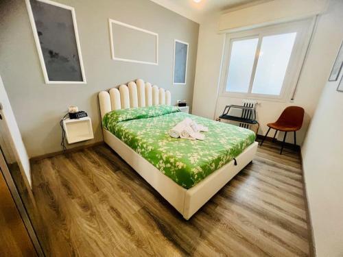 una camera da letto con un grande letto con una coperta verde di In centro, silenzioso e balcone a Sanremo