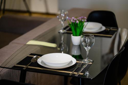 a table with plates and wine glasses and flowers at Luxury Apartments-Belochka in Uzhhorod