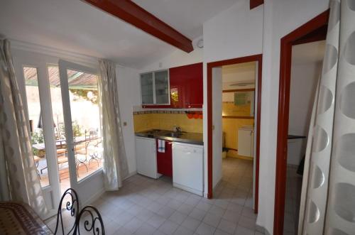 a kitchen with red and yellow cabinets and a sink at Le Clos des Galéjades in Porquerolles