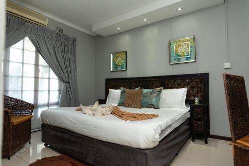 a bedroom with a large bed with white sheets at Mumses Guest House in Ramotswa