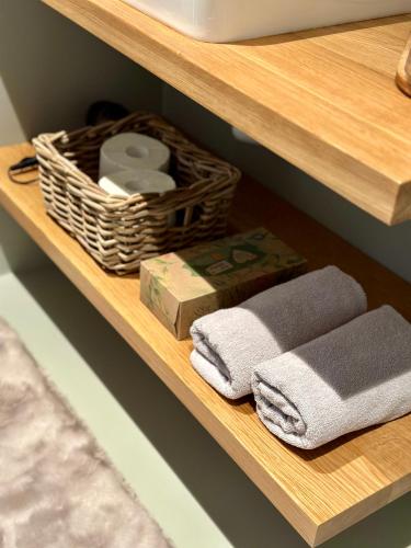 a wooden shelf with towels and a basket on it at Apartmán Vinařství Eisgrub in Lednice