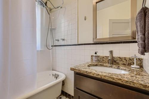 a bathroom with a sink and a tub and a toilet at Redbrick Cottage 2BDRM Wash Park Yard & Gym in Denver