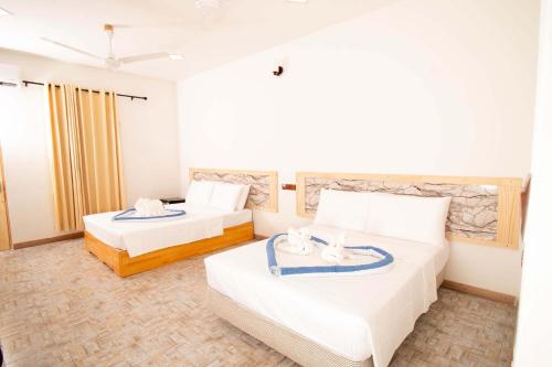 a hotel room with two beds with towels on them at ONE SEASON THODDOO in Thoddoo
