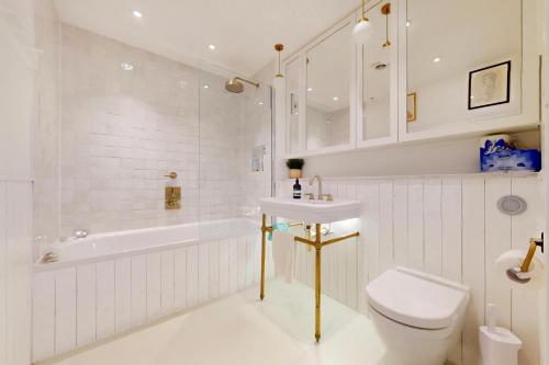 a white bathroom with a sink and a toilet at 2Bed Flat w Lift & Balcony -10min to Tube Station in London