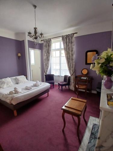 a bedroom with a bed and a living room at La Granitiere Maison de Charme in Saint-Vaast-la-Hougue