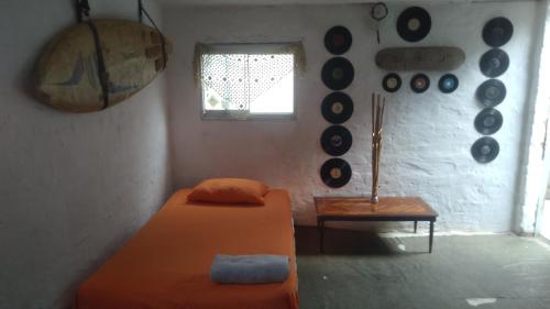 Habitación con cama y discos en la pared en Huanchaco Surf Camp, en Huanchaco