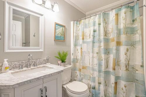 a bathroom with a toilet and a shower curtain at Sea Cabin- Ocean Front Condo in Myrtle Beach