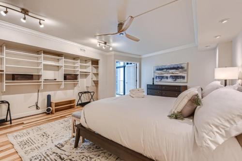 a white bedroom with a large bed and a tv at Larimer Luxury Top Notch Amenities Walk to All in Denver