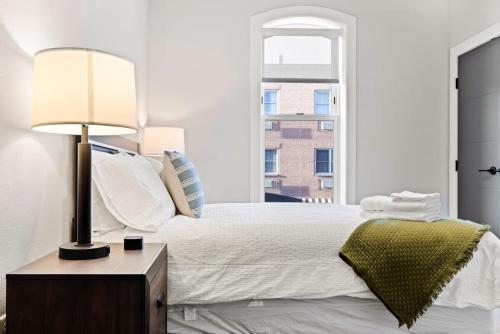 1 dormitorio con 1 cama con lámpara y ventana en Avenue Hotel Downtown Golden Clear Creek Suite, en Golden