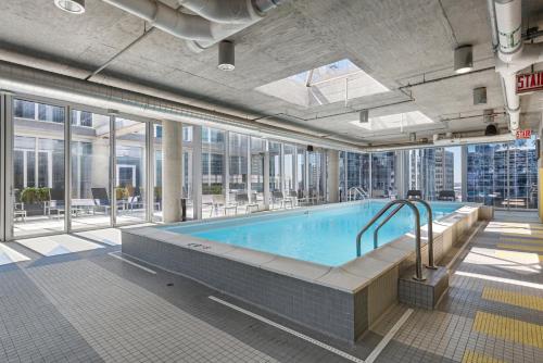 a large swimming pool in a building with windows at Linea Luxury Living with Indoor Pool and Rooftop Views in The Loop in Chicago