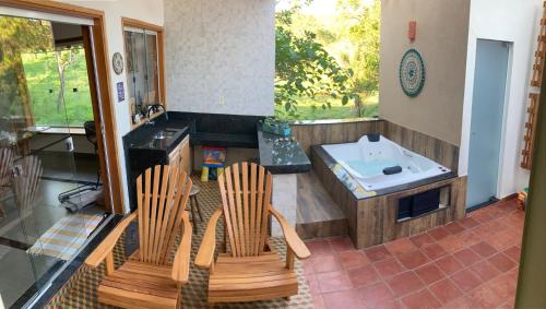 a kitchen with two chairs and a tub at Casa Janela Verde in São José da Barra