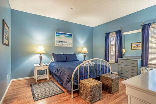 1 dormitorio con paredes azules y 1 cama en una habitación en Teal lake 1311, en North Myrtle Beach