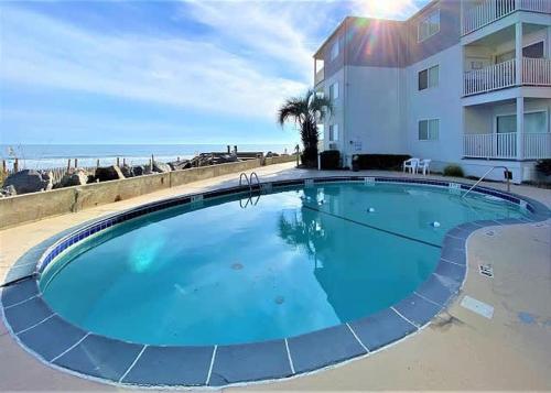 a large blue swimming pool in front of a building at The Sea Shed- Ocean Front Condo in Myrtle Beach