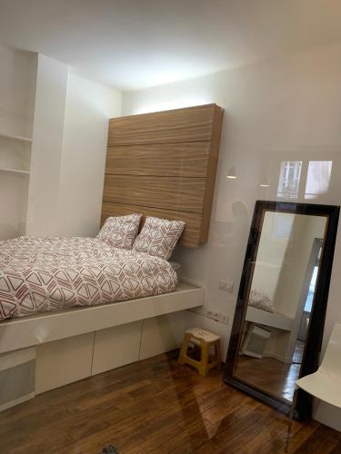 une petite chambre avec un lit et un miroir dans l'établissement loft Montmartre au pieds des vignes, à Paris