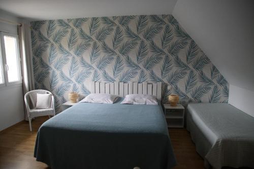 a bedroom with a bed with a blue and white wallpaper at LE SECHOIR DANTAN in Doudeville