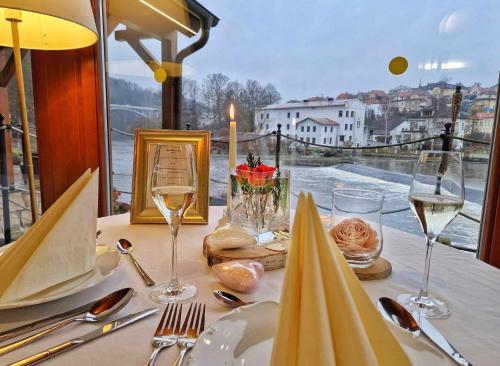 - une table avec des verres de vin et une vue sur l'eau dans l'établissement ROMANTIK HOTEL ELEONORA, à Tábor