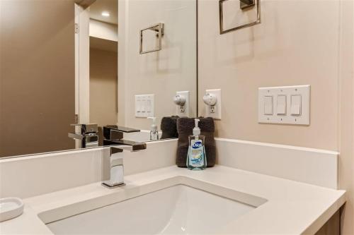 a white bathroom with a sink and a mirror at Serenity at Sloan's 1-BR with a Modern Twist in Denver