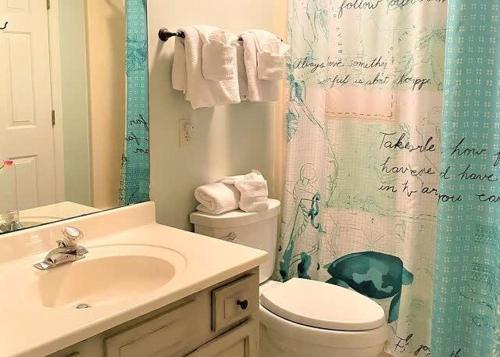 uma casa de banho com um lavatório, um WC e uma cortina de chuveiro. em Teal Lake 212 em North Myrtle Beach