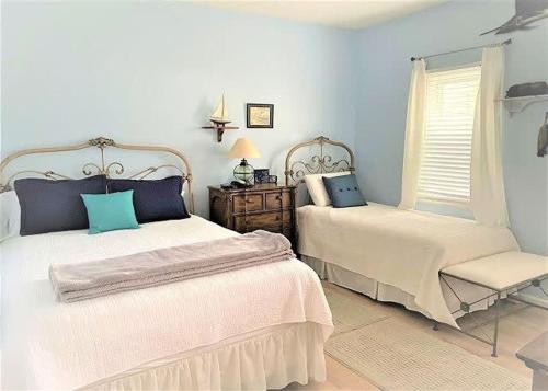 a bedroom with two beds and a chair and a window at Teal Lake 212 in North Myrtle Beach