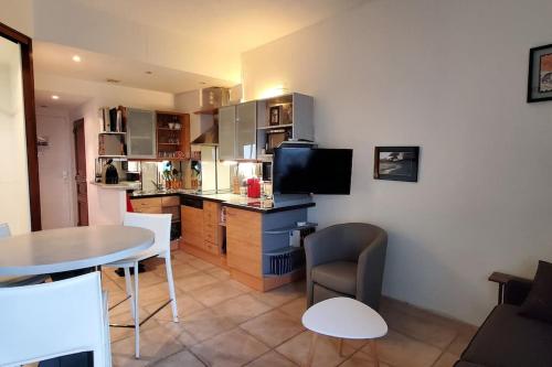 uma sala de estar com uma mesa e uma cozinha em bienvenue au Manava em La Grande-Motte
