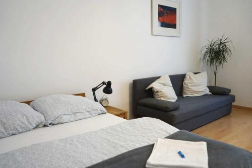 ein Schlafzimmer mit einem Bett und einem Sofa in der Unterkunft Serenity Apartment 45m2 Free Parking in Leoben