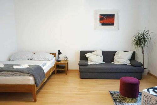 ein Schlafzimmer mit einem Bett und einem Sofa in der Unterkunft Serenity Apartment 45m2 Free Parking in Leoben