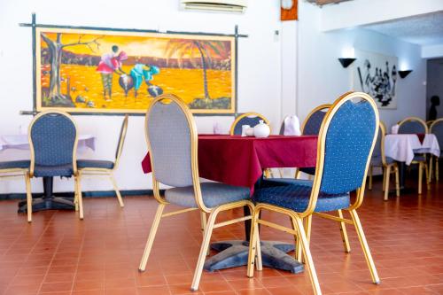a dining room with a table and four chairs at Sarges Hotel in Sere Kunda
