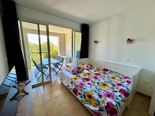 une chambre avec un lit et un balcon avec une table dans l'établissement Les Restanques 2036 rez jardin Jonquilles, à Grimaud