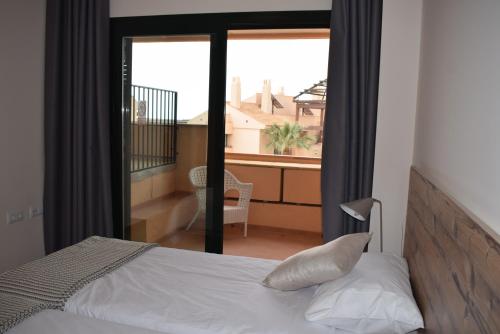 Fuente Alamo的住宿－Apt. Bascath，一间卧室设有一张床,享有阳台的景色