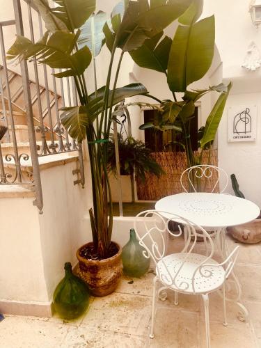 a table and two chairs and a potted plant at Corte San Giorgio in Matino