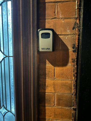 a cell phone sticking out of the side of a door at Crete Room in Oldham