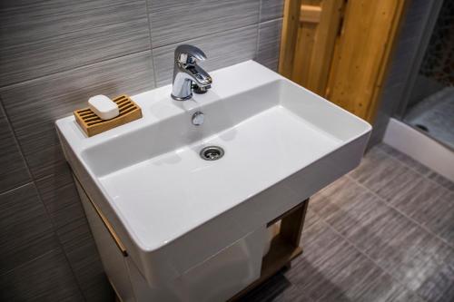 a white sink in a bathroom with a shower at Apartmány ve Dvoře in Herálec