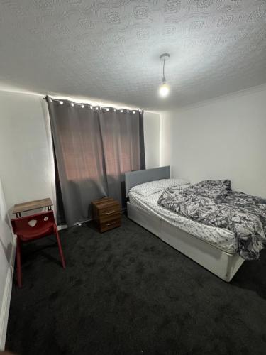 a bedroom with a bed and a table in it at Crete Room in Oldham