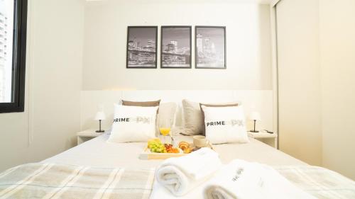 a white bedroom with a tray of fruit on a bed at Flat Jardim Paulista II - SP - Próximo da AV Paulista e ao lado do Shopping Pamplona in Sao Paulo